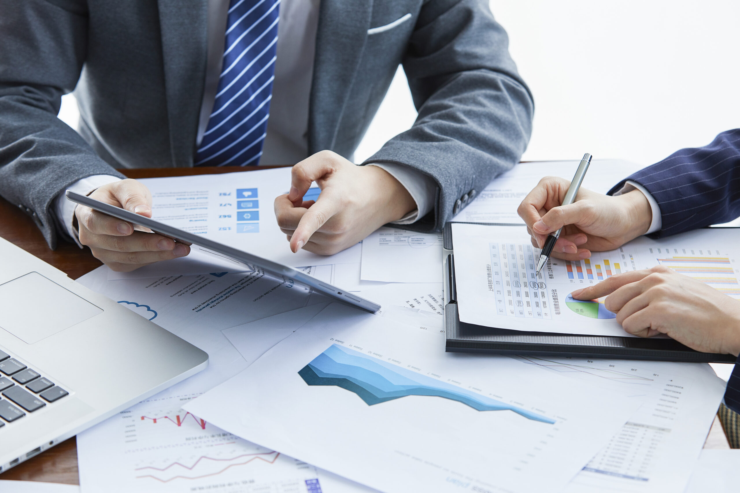 Two professionals analysing financial charts at a desk, representing R&D collaboration and investment planning.