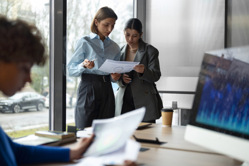 Two women in an office reviewing a document together, highlighting cross-sector R&D partnerships and teamwork.