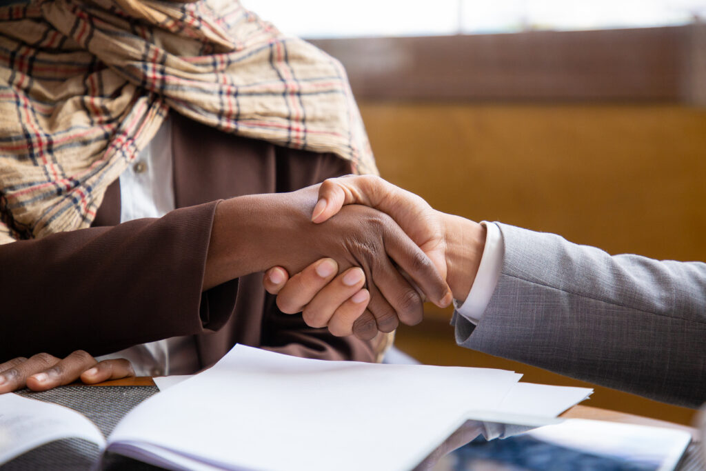 Close-up of business professionals pointing at and reviewing a physical document, representing funding contracts.