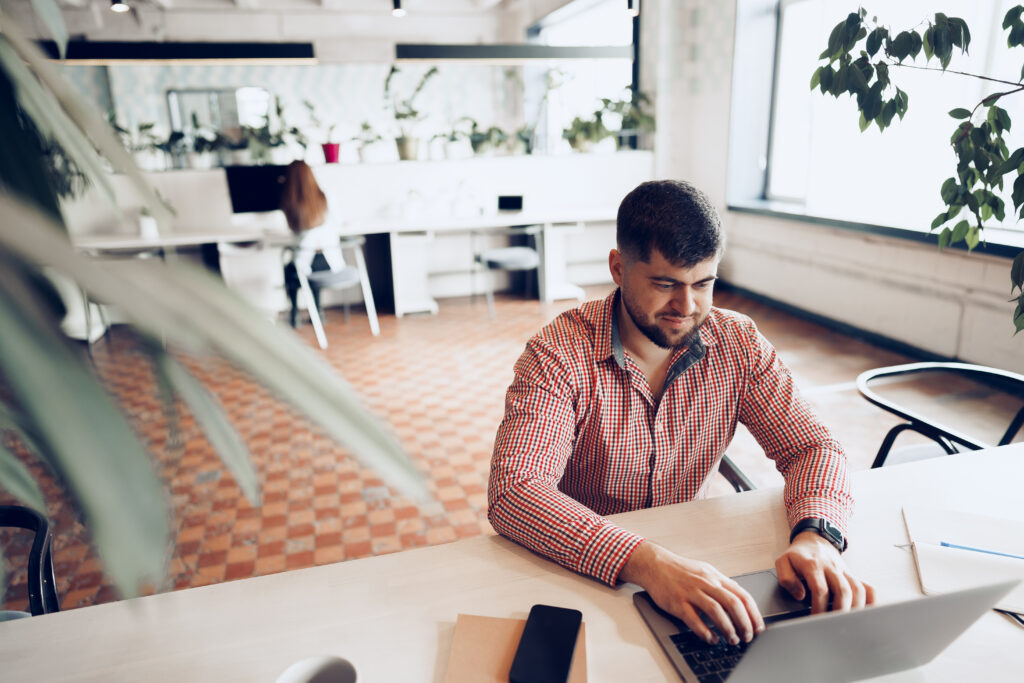 Startup founder typing on a laptop in a bright office, highlighting the rise of alternative finance in Australia.